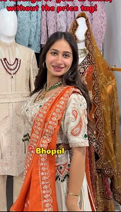 A customer in an orange bandhani lehenga next to sherwanis